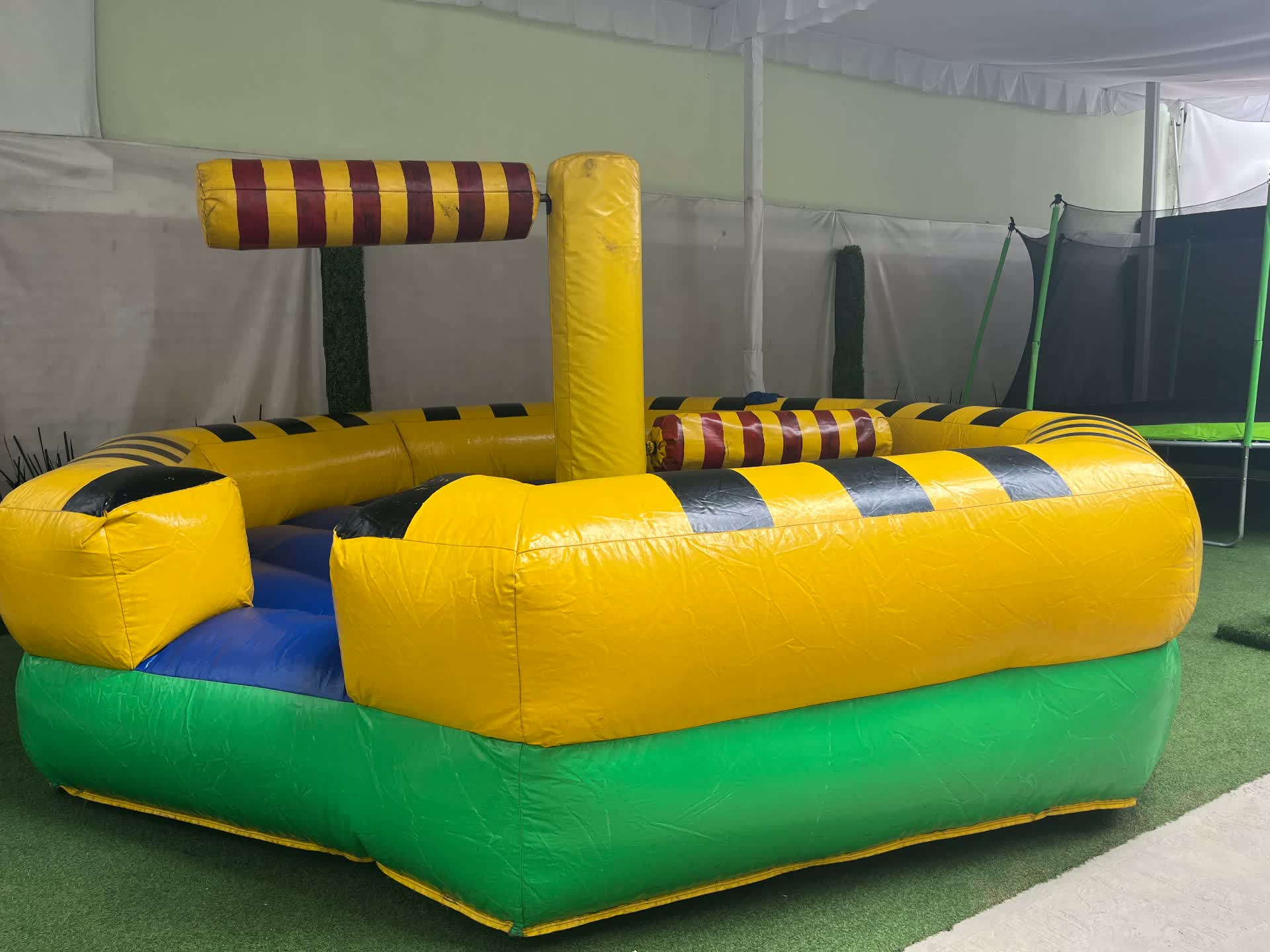 Juego inflable tipo gladiadores en amarillo y verde para eventos infantiles