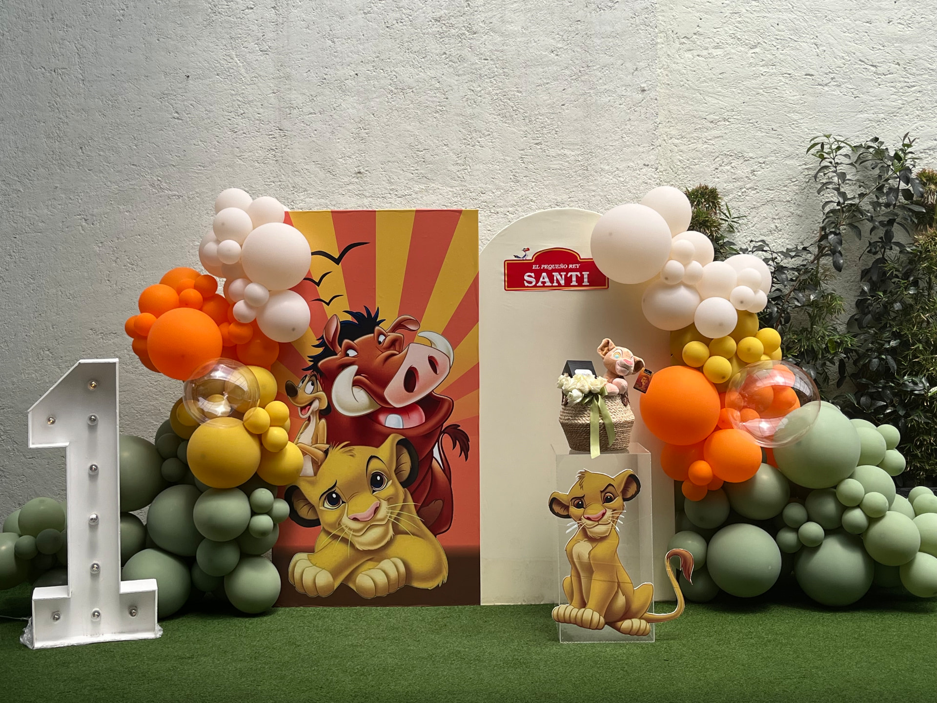 Decoración temática de El Rey León con globos y número uno luminoso